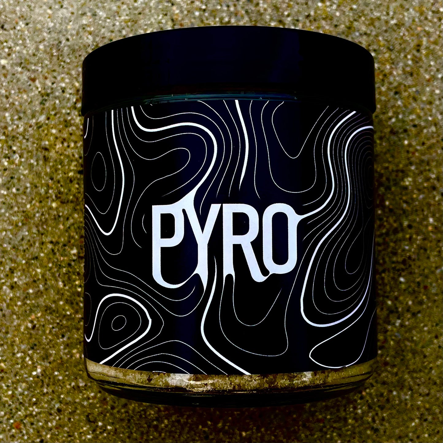 PYRO sea salt bath product with added microalgae extract sand background